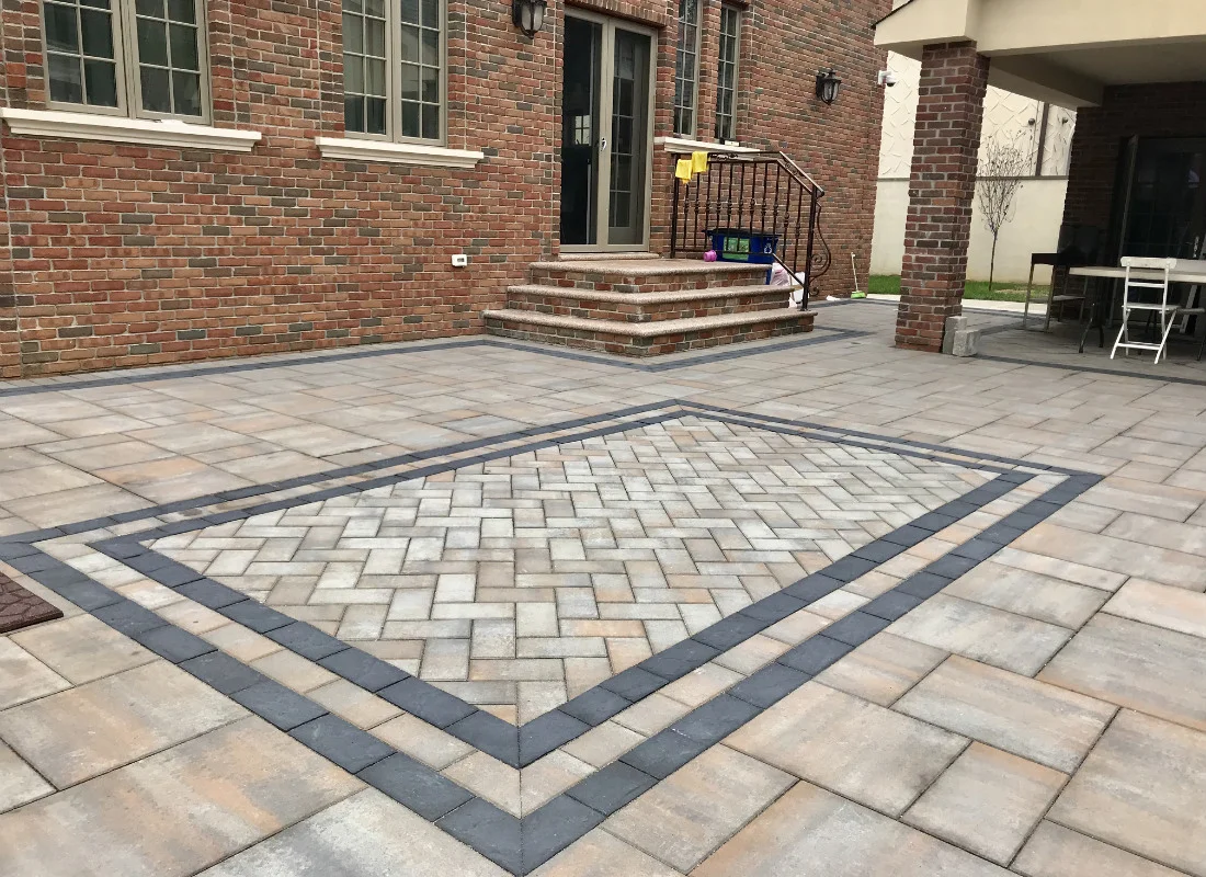 Geometric paver patio with contrasting borders and brick entry steps