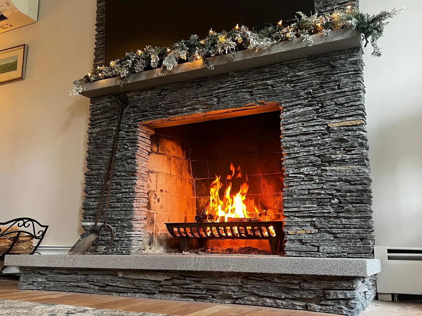 Outdoor stone fireplace beside a paved seating area