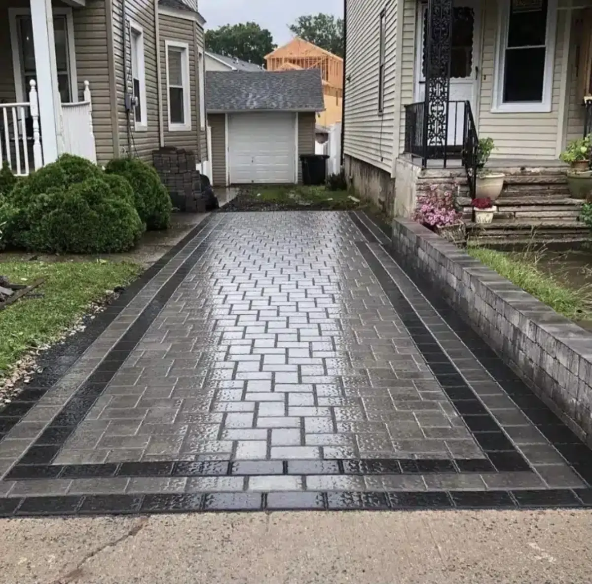 Finished paver driveway leading to a detached garage