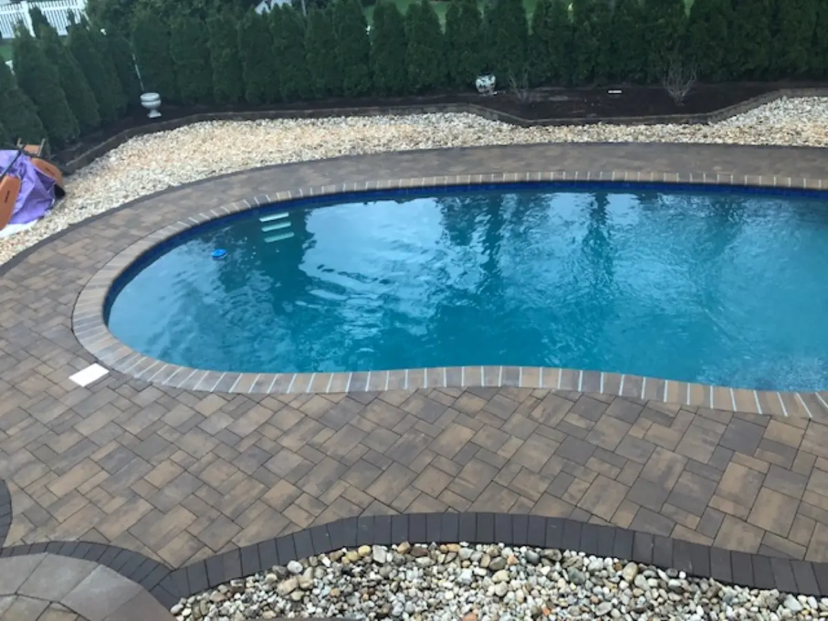 Swimming pool surrounded by a paver patio